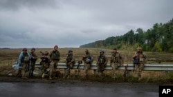 Ukrainian servicemen rest at a former Russian position in the recently retaken area of Izium, Ukraine, Sept. 16, 2022. 
