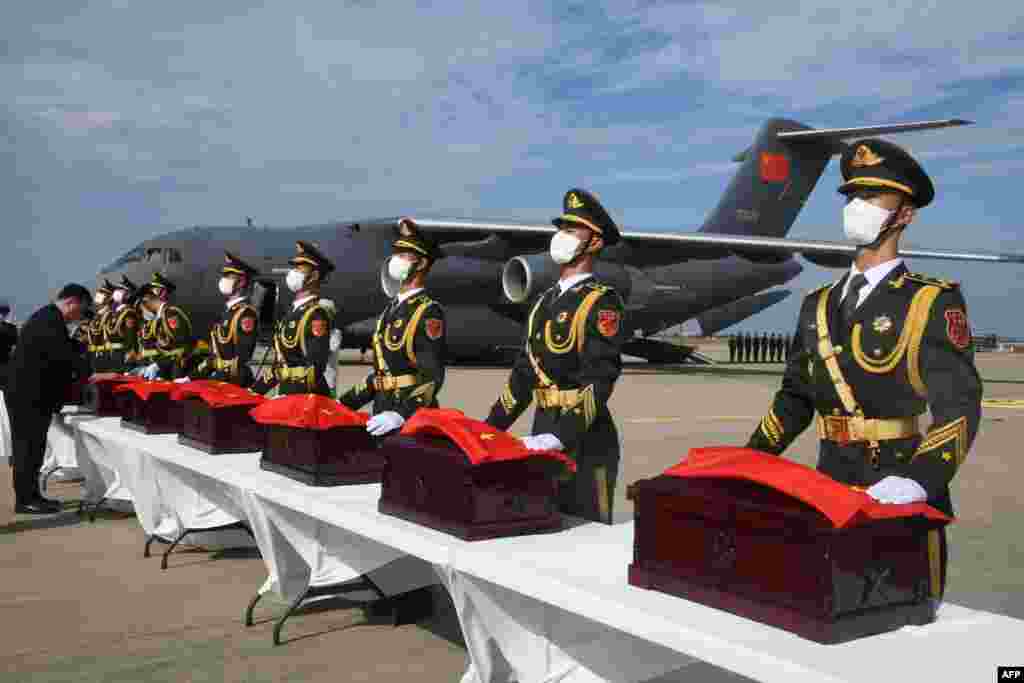 Chinese soldiers carry caskets containing the remains of Chinese soldiers during the handing over ceremony at the Incheon International Airport in Incheon, South Korea.