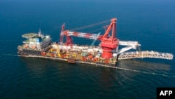 FILE - This picture taken in Sept. 2021, provided by Nord Stream 2 AG, shows specialists on laybarge performing an above water tie-in during the final stage of Nord Stream 2 pipeline construction in the Baltic Sea. (Photo by Handout/Nord Stream 2 AG/AFP)