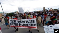 FILE - Demonstrators move along Interstate 225 after stopping traffic during a rally and march over the death of 23-year-old Elijah McClain, June 27, 2020, in Aurora, Colo.