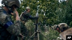 Ukrainian soldiers fire in recently retaken Kupiansk in the Kharkiv region, Ukraine, Sept. 22, 2022.
