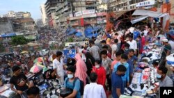 FILE - People shop at a market in Dhaka, Bangladesh, July 16, 2021. The country's economic miracle is under severe strain as fuel price hikes amplify public frustrations over rising costs for food and other necessities.