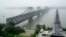 FILE - Visitors cross the Yalu River Broken Bridge, right, next to the Friendship Bridge connecting China and North Korea in Dandong China, Sept. 9, 2017. North Korea and China resumed freight train service, Sept. 26, 2022, after a five-month hiatus, South Korean officials said.