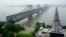 FILE - Visitors cross the Yalu River Broken Bridge, right, next to the Friendship Bridge connecting China and North Korea in Dandong China, Sept. 9, 2017. North Korea and China resumed freight train service, Sept. 26, 2022, after a five-month hiatus, Sout