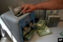 Seorang pekerja di biro penukaran uang menghitung pound Lebanon di Beirut, Lebanon, Kamis, 22 September 2022. (AP/Bilal Hussein)