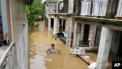 A resident wades through chest-deep floodwater from to Typhoon Noru in San Miguel town, Bulacan province, Philippines, Sept. 26, 2022. Typhoon Noru blew out of the northern Philippines on Monday, leaving some people dead, causing floods and power outages.