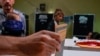 Eleitor descarrega o voto na urna, numa assembleia de voto em Roma, Itália, 25 de setembro. 