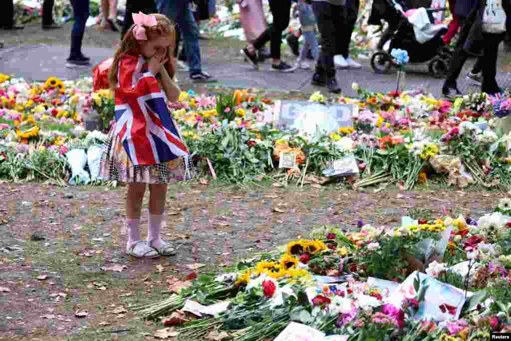 Six-year-old Ann Doran reacts near floral tributes left at Green Park, following the death of Britain's Queen Elizabeth, in London, Britain.