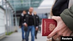 Seseorang memegang Paspor Rusia di titik penyeberangan perbatasan Vaalimaa antara Rusia dan Finlandia, di Vaalimaa, Finlandia, 23 September 2022. (Foto: REUTERS/Janis Laizans)