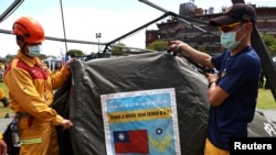 Firefighters show the Taiwanese flag on their tent at a drill on Taiwan's annual earthquake and national disaster prevention day, after an earthquake in the southeastern part of the quake-prone island, in Hualien, Taiwan, Sept. 21, 2022. 
