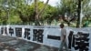 资料照：一名男子走过台北街头悬挂的写有“投资中国死路一条”字样的标语。（2012年8月8日）（路透社)