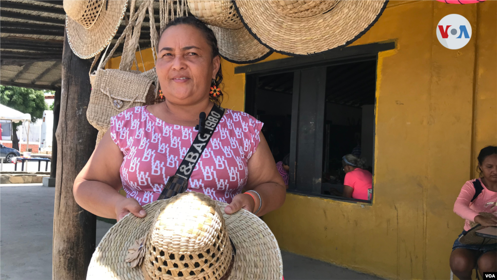 María Guaiquirima de la etnia cumanagoto muestra los sombreros que elabora con junco.