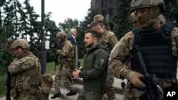 Ukrainian President Volodymyr Zelenskyy leaves after attending a national flag-raising ceremony in the freed Izium, Ukraine, Sept. 14, 2022. 