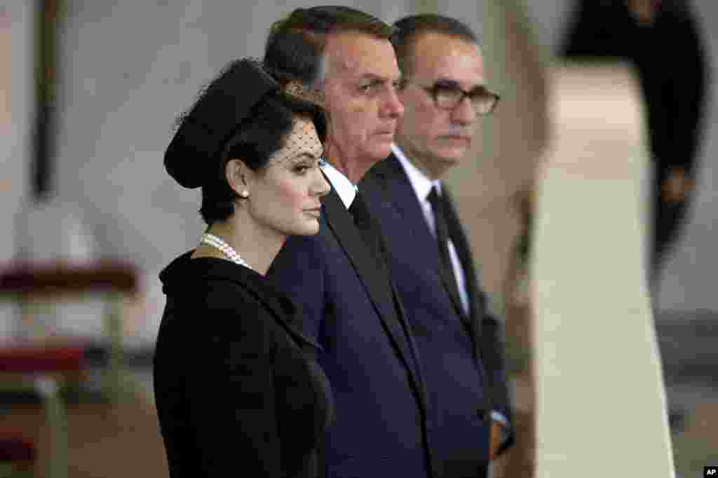 President Jair Bolsonaro of Brazil, center, and his wife Michelle pay their respects to Queen Elizabeth II inside Westminster Hall in London, Sept. 18, 2022.