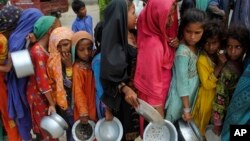 Children from flood-affected areas wait to receive food aid, in Lal Bagh, Sindh province, Pakistan, Sept. 13, 2022.