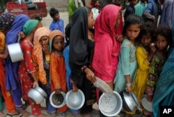 Anak-anak dari daerah yang terdampak banjir antre untuk menerima bantuan makanan, di Lal Bagh, provinsi Sindh, Pakistan, 13 September 2022.
