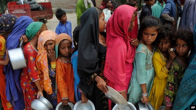 Children from flood-affected areas wait to receive food aid, in Lal Bagh, Sindh province, Pakistan, Sept. 13, 2022.