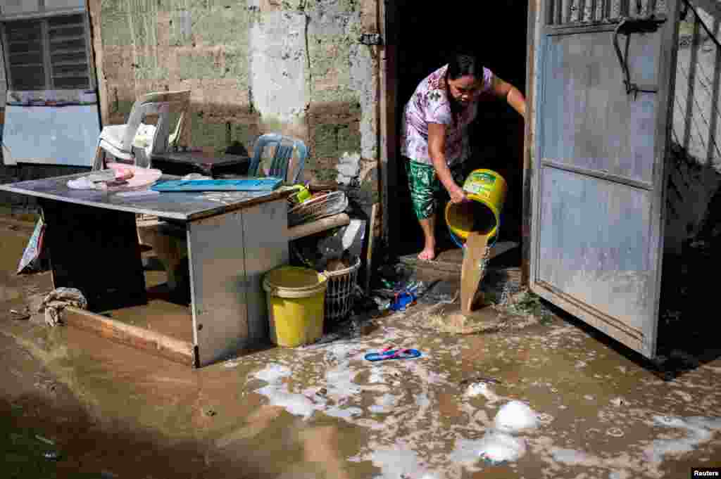 A woman clears her home from mud following the flood caused by Super Typhoon Noru, in Marikina City, Metro Manila, Philippines, Sept. 26, 2022.
