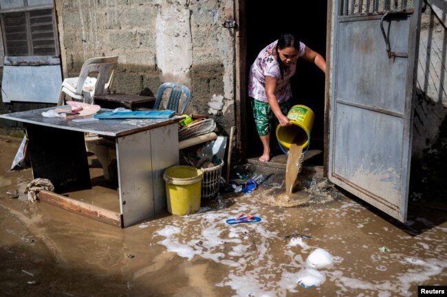 A woman clears her home from mud following the flood caused by Super Typhoon Noru, in Marikina City, Metro Manila, Philippines, Sept. 26, 2022. (REUTERS/Lisa Marie David)