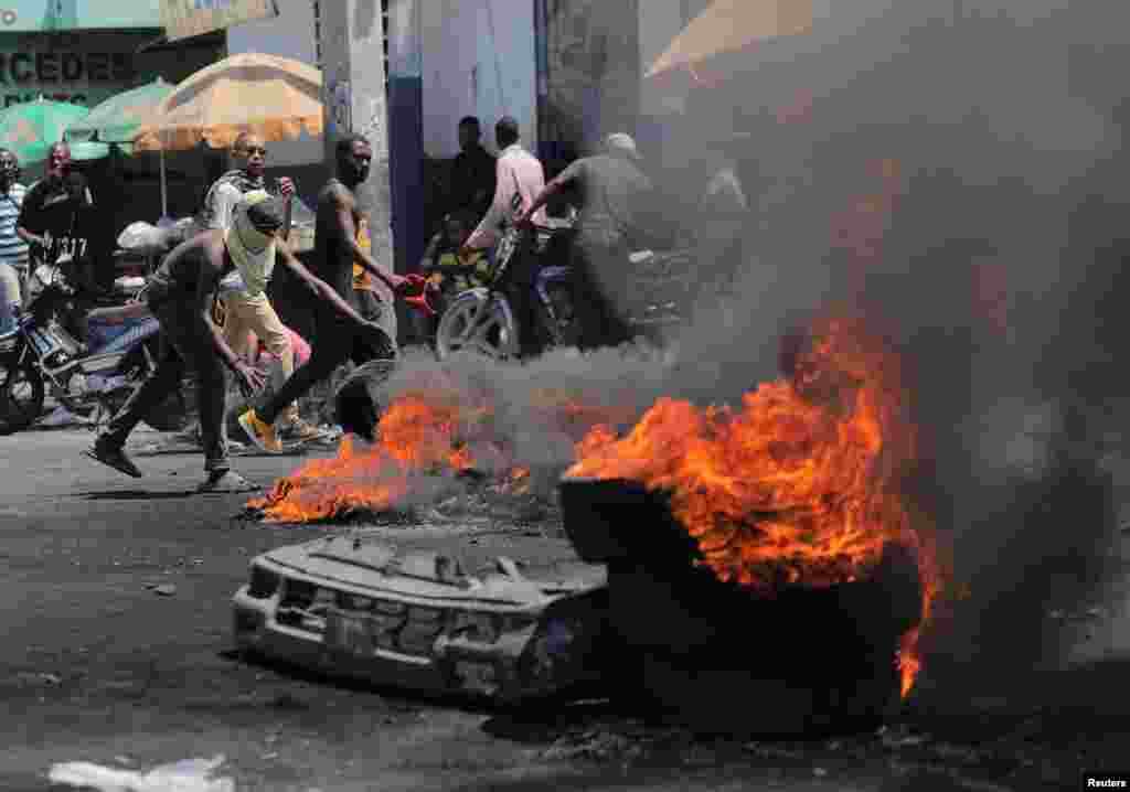 Los manifestantes se reúnen cerca de una barricada en llamas durante las protestas por el aumento de los precios del combustible y el crimen cuando la inflación alcanzó su nivel más alto en una década, en Puerto Príncipe, Haití, el 14 de septiembre de 2022.