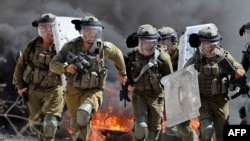 Pasukan keamanan Israel berlari ke arah demonstran Palestina selama bentrokan menyusul protes terhadap pengambilalihan tanah Palestina oleh Israel di desa Kfar Qaddum, Tepi Barat, wilayah Palestina yang diduduki Israel (foto: dok). 