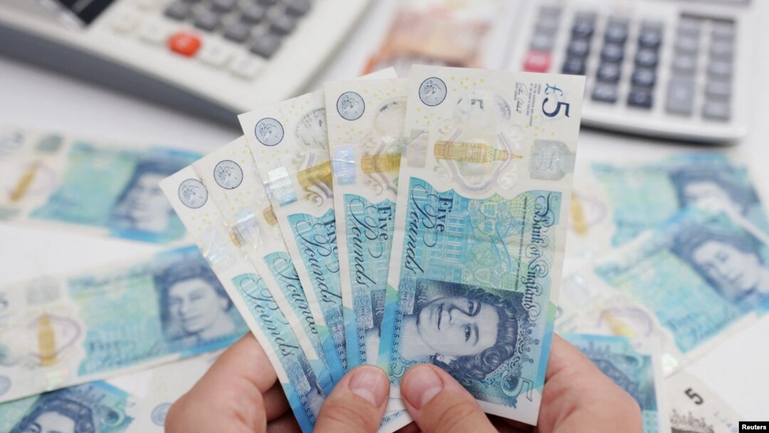 FILE - Woman holds British pound banknotes in this illustration taken May 30, 2022. (Reuters/Dado Ruvic/Illustration)
