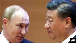 Russian President Vladimir Putin, left, speaks to Chinese President Xi Jinping during the Shanghai Cooperation Organization (SCO) summit in Samarkand, Uzbekistan, Sept. 16, 2022.