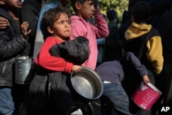 Anak-anak Palestina antre untuk mendapat makan di Deir-al-Balah, Jalur Gaza, Jumat, 13 Desember 2024. (Foto: Abdel Kareem Hana/AP Photo)