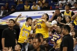 Chinese fans react during a preseason NBA basketball game between the Brooklyn Nets and Los Angeles Lakers at the Mercedes Benz Arena in Shanghai, China, Oct. 10, 2019.