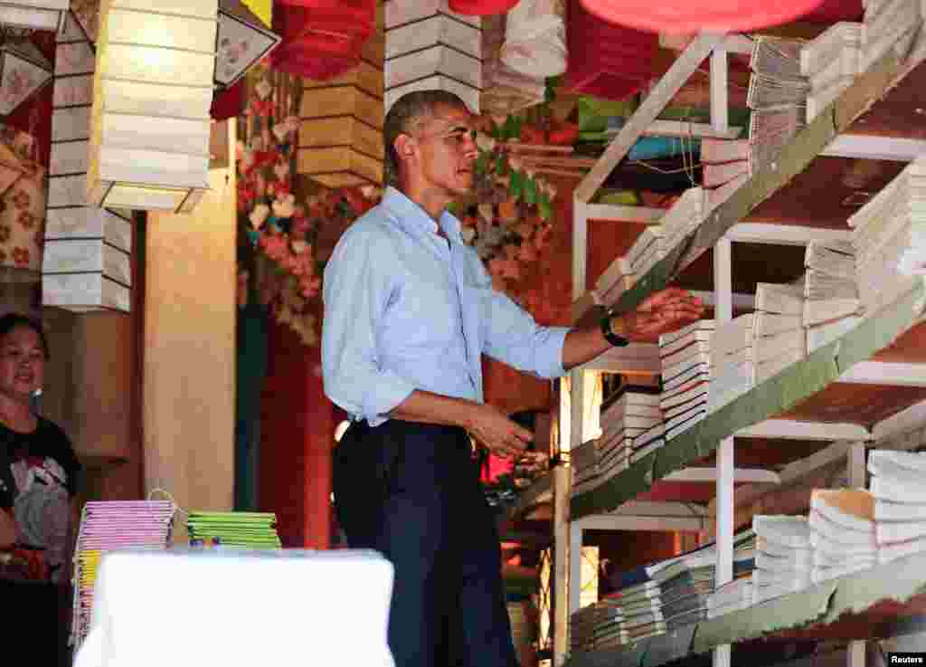 President Barack Obama shops for paper goods and lanterns on a walk in Luang Prabang, Sept. 7, 2016.