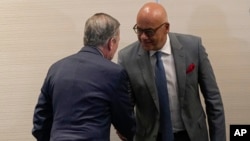 Gerardo Blyde, de la opositora Plataforma Unitaria, de espaldas, y Jorge Rodríguez, jefe delegado del oficialismo venezolano, se saludan en el marco de las negociaciones en Ciudad de México, el 26 de noviembre de 2022.