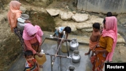 FILE - Rohingya refugees collect drinking water at the Shalbagan refugee camp in Teknaf, Bangladesh, March 5, 2019. 