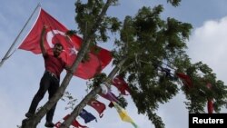 FILE - A supporter of Turkey's main pro-Kurdish Peoples' Democratic Party (HDP) stands in a tree during a campaign event in Istanbul, Turkey, May 25, 2018.