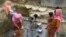 FILE - Rohingya refugees collect drinking water at the Shalbagan refugee camp in Teknaf, Bangladesh, March 5, 2019. 