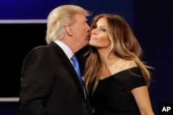 FILE - Republican presidential nominee Donald Trump kisses wife Melania Trump after the presidential debate at Hofstra University in Hempstead, N.Y., Sept. 26, 2016.