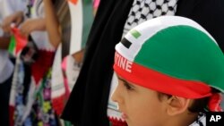 Anak-anak Bahrain membawa bendera Palestina berpartisipasi dalam pawai di Manama, Bahrain, 17 Juli 2014.