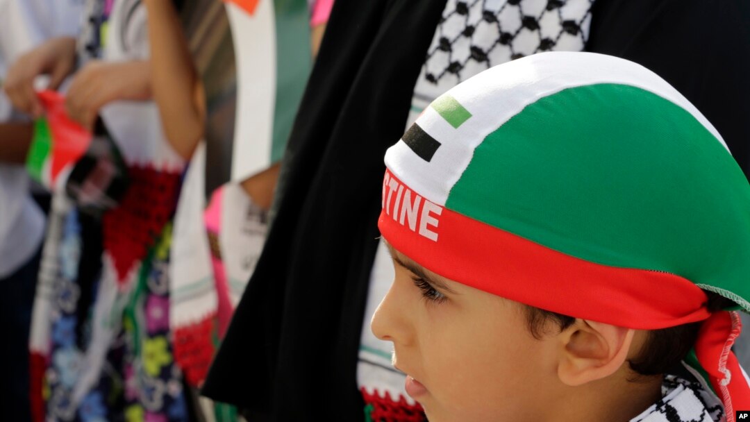 Anak-anak Bahrain membawa bendera Palestina berpartisipasi dalam pawai di Manama, Bahrain, 17 Juli 2014.