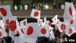 Kaisar Akihito (tengah kiri), permaisuri Michiko (tengah kanan) dan anggota keluarga kekaisaran Jepang melambaikan tangan kepada warga yang memadati halaman Istana Kekaisaran Tokyo dalam perayaan tahun baru (2/1).