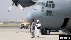 Taliban berjalan di depan pesawat militer sehari setelah penarikan pasukan AS dari Bandara Internasional Hamid Karzai di Kabul, Afghanistan 31 Agustus 2021. (Foto: Reuters)