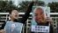 FILE - Pro-democracy activists hold pictures of Chinese activists Wu Gan, right, and Qin Yongmin outside the Chinese central government's liaison office in Hong Kong, Dec. 27, 2017.