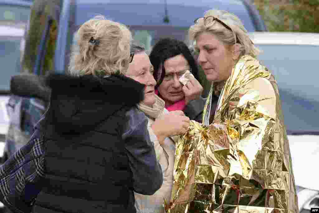 People comfort a survivor on the site of a collision in Puisseguin, near Libourne, southwestern France. At least 42 people, most of them elderly, were killed when a bus collided with a truck and caught fire in southwestern France.