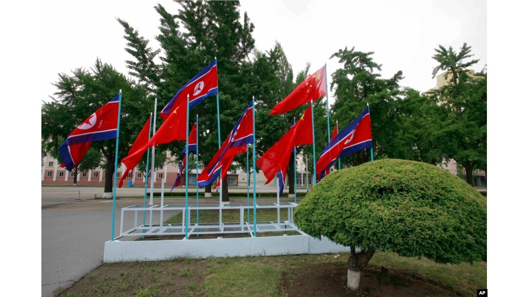 Banderas nacionales de Corea del Norte y China adornan una calle en Pyongyang, Corea del Norte, el 20 de junio de 2019, con motivo de la visita del presidente de China, Xi Jinping.