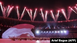 Kembang api menghiasi langit saat para peserta tampil pada upacara pembukaan Asian Para Games 2018 di stadion utama Gelora Bung Karno di Jakarta, sebagai ilustrasi. ASEAN Para Games 2022 resmi dibuka Sabtu (30/7) malam. (Foto: AFP/Arief Bagus)