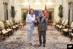 In this photo provided by Ministry of Communications and Information, Singapore, U.S. House Speaker Nancy Pelosi, left, and Singapore President Halimah Yacob shake hands at the Istana Presidential Palace in Singapore, Monday, Aug. 1, 2022.