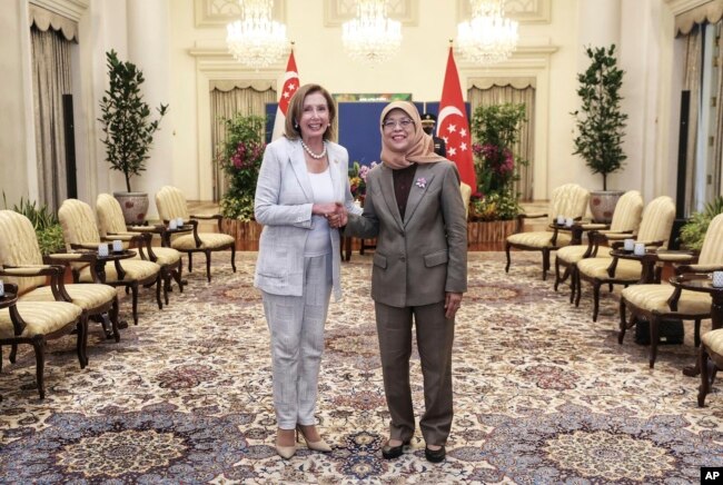 In this photo provided by Ministry of Communications and Information, Singapore, U.S. House Speaker Nancy Pelosi, left, and Singapore President Halimah Yacob shake hands at the Istana Presidential Palace in Singapore, Monday, Aug. 1, 2022.