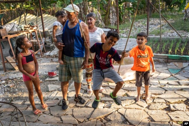 FILE - Gustavo Pijuan and his wife, Sura Victorero, are pictured with their grandchildren at their home in Minas, Cuba, April 29, 2022. Cuba's new Families Code contains an extension of rights of grandparents.(AP Photo/Ramon Espinosa)