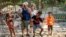 FILE - Gustavo Pijuan and his wife, Sura Victorero, are pictured with their grandchildren at their home in Minas, Cuba, April 29, 2022. Cuba's new Families Code contains an extension of rights of grandparents.