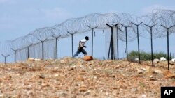 FILE: A Zimbabwean man flees across border near Beitbridge Border Post in Musina, South Africa, Friday March 28, 2008. Zimbabwe goes to the polls on Saturday amid growing international concern that President Robert Mugabe intends to manipulate the vote. (AP Photo/Themba Hadebe)