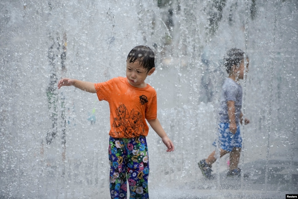 上海酷暑中小朋友在喷水池中冲凉。（2022年7月22日）(photo:VOA)
