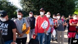 Emigrantët duke mbajtur batanijet e dhëna nga Kryqi i Kuq, pasi kanë zbritur nga autobuzët nga Teksasi në kryeqytetin amerikan Uashington